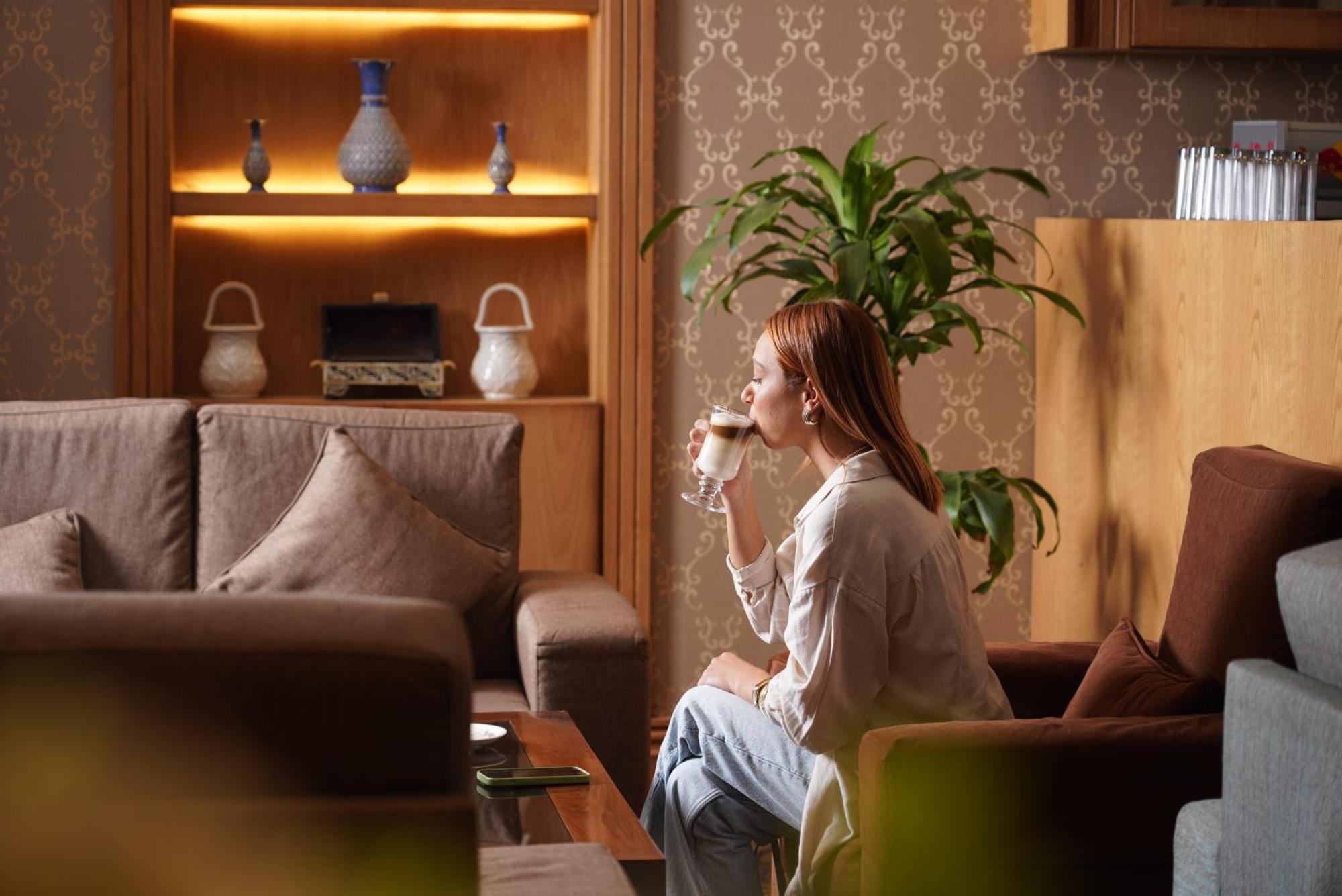 Thousand Nights Hotel Amman Luaran gambar A woman drinking coffee